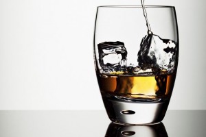 Alcohol pouring into highball glass with ice cubes-1736688